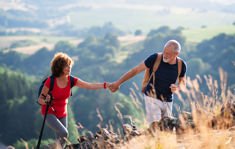 A couple travelling and hiking together on a mountain.