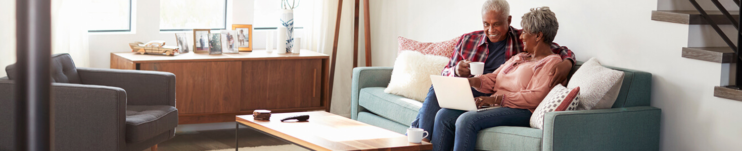 Couple sitting on the couch browsing the internet.