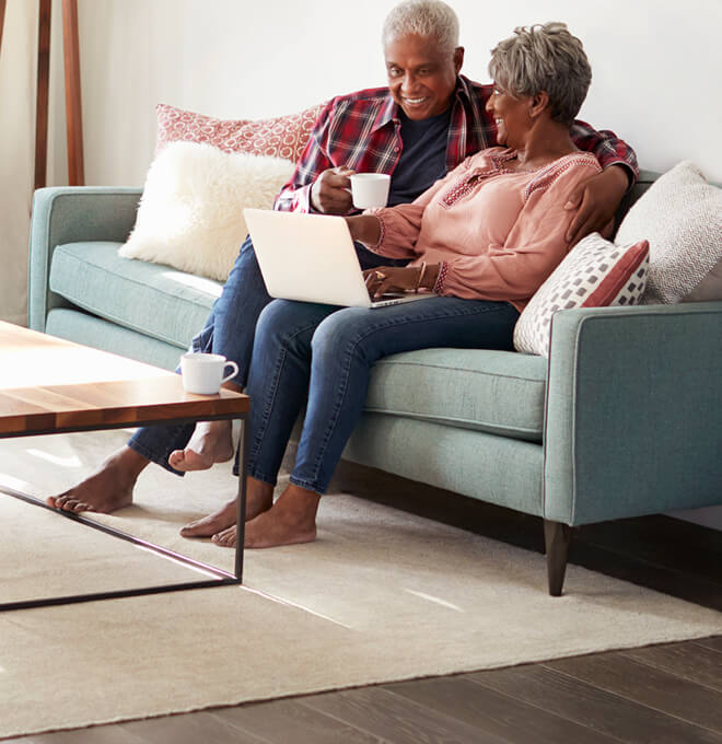 Couple sitting on the couch browsing the internet.