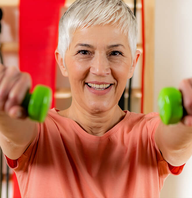 Lady using weights to exercise.