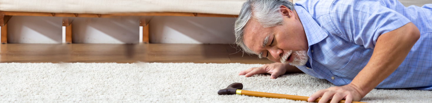 Man lying on the floor with a cane