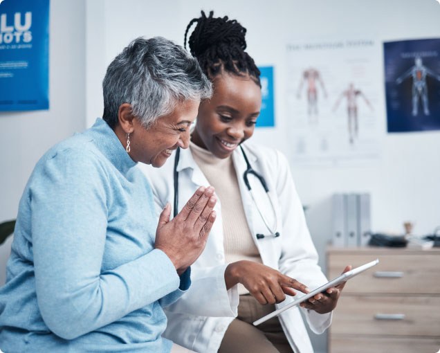 A doctor and patient smile while reviewing the patient's health info.